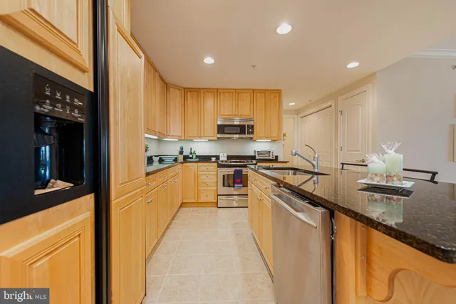a kitchen with kitchen island granite countertop a sink counter top space and stainless steel appliances