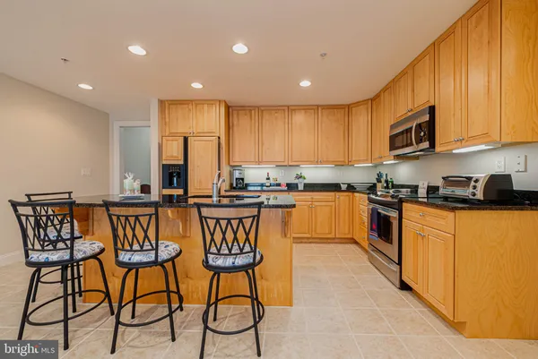 a kitchen with stainless steel appliances granite countertop wooden cabinets a stove a sink and a granite counter tops