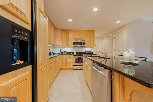 a kitchen with kitchen island granite countertop a sink counter top space and stainless steel appliances