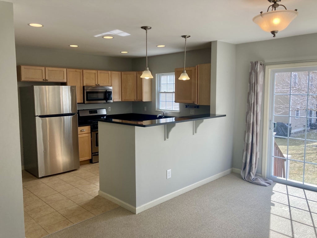 45 Turtle Brook Road, Unit 45 Canton, MA 02021 - Photo 2 of 14 a kitchen with kitchen island a counter top space a sink stainless steel appliances and cabinets