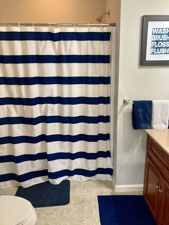 45 Turtle Brook Road, Unit 45 Canton, MA 02021 - Photo 9 of 14 a bathroom with a toilet and a shower curtain