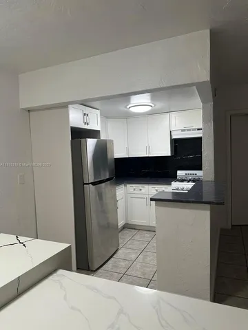 a kitchen with a refrigerator and a stove top oven