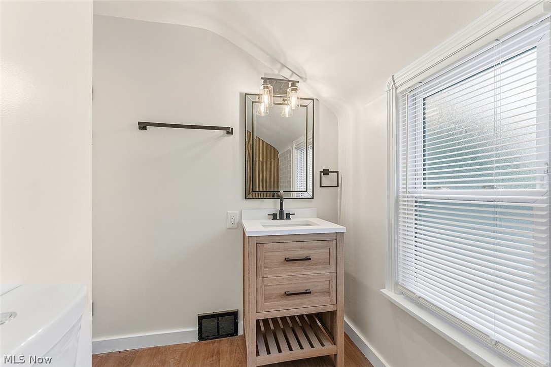 3791 Fairoaks Road South Euclid, OH 44121 - Photo 22 of 30 Bathroom featuring a wood-finish vanity with a white countertop, a black framed mirror, and a contemporary light fixture