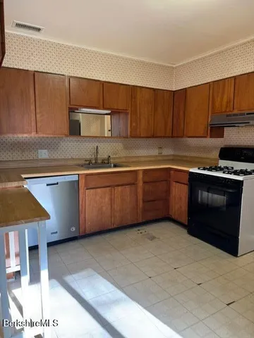 a kitchen with stainless steel appliances granite countertop a sink stove and cabinets