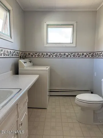 a bathroom with a toilet a sink and a window