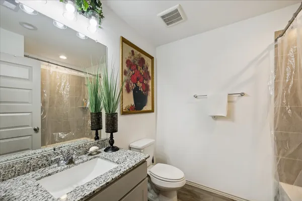 a bathroom with a granite countertop sink toilet and shower