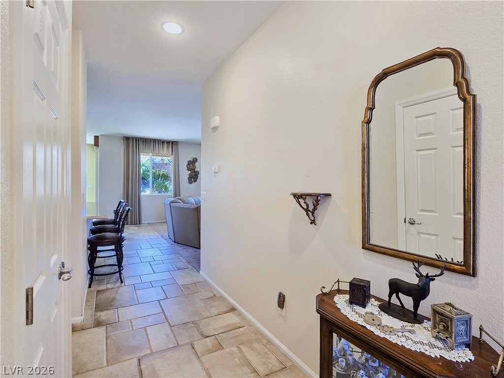 2485 Morrow Ridge Place Laughlin, NV 89029 - Photo 7 of 40 A well-lit hallway with large tile flooring leads to a sun-filled living area.