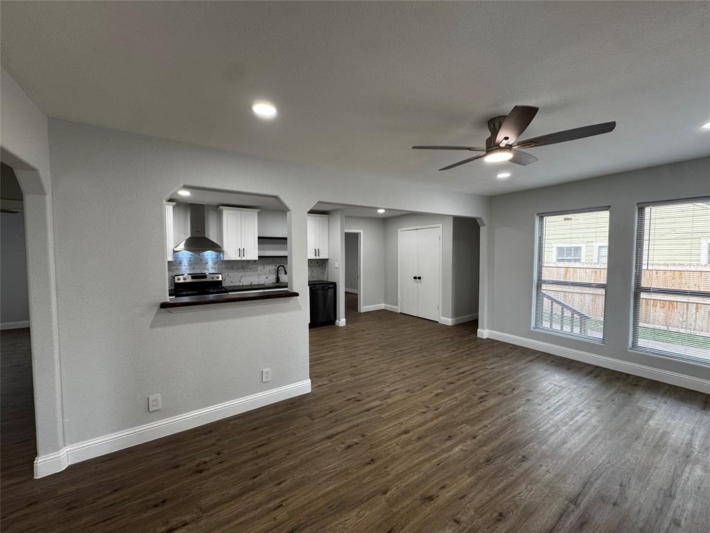 2909 Alexander Avenue Waco, TX 76708 - Photo 6 of 27 a view of a kitchen and an empty room with wooden floor and a window