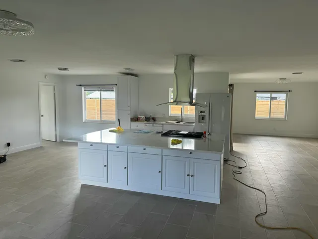 a spacious bathroom with a granite countertop sink a mirror and a bathtub
