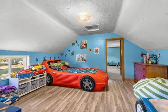 a bedroom with bed and a wooden floor