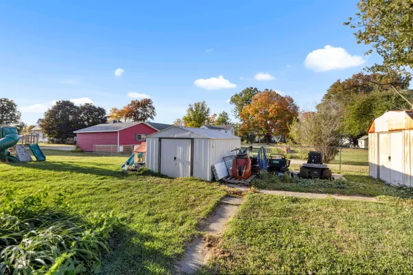 a kitchen with granite countertop a sink cabinets stainless steel appliances and a window