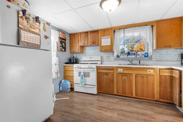 a kitchen with granite countertop a sink cabinets stainless steel appliances and a window