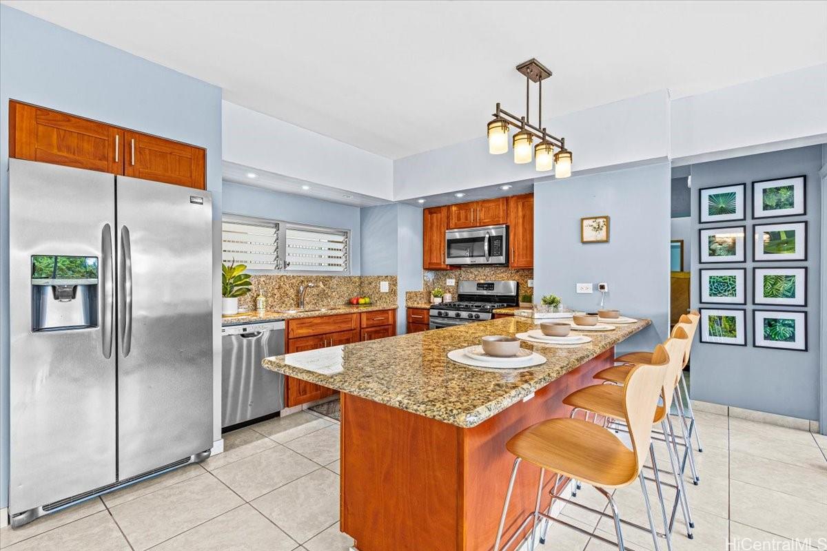 2161 Kalia Road, Unit 402 Honolulu, HI 96815 - Photo 7 of 25 a kitchen with stainless steel appliances granite countertop table chairs and a refrigerator