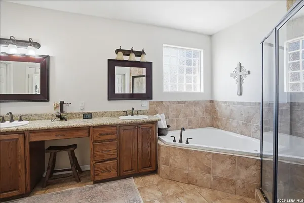 a bathroom with a tub a sink and mirror