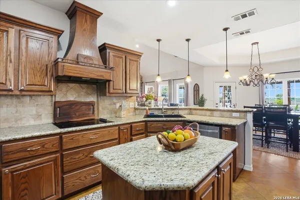 a kitchen with stainless steel appliances granite countertop a sink a stove and a wooden floors