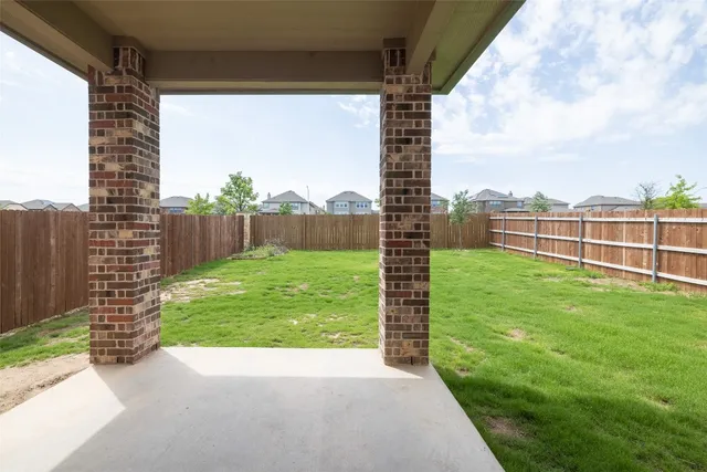 a view of a porch with a big yard and a large tree