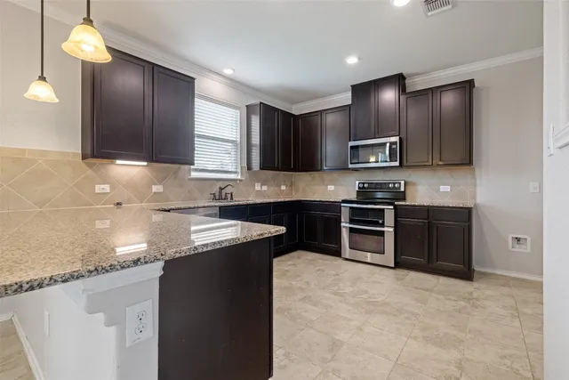 a kitchen with stainless steel appliances granite countertop a sink stove and refrigerator