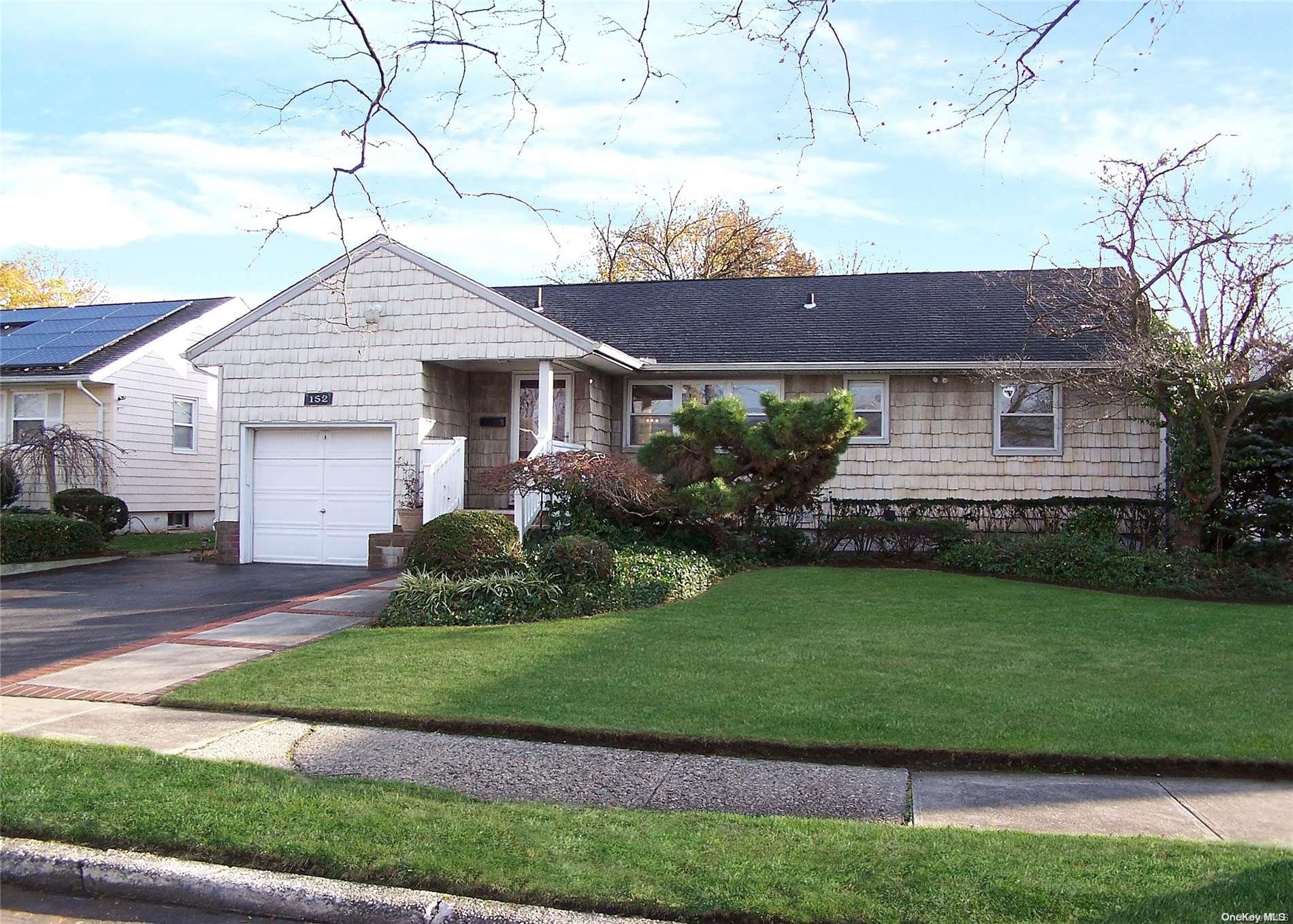 Asphalt driveway and mature landscaping