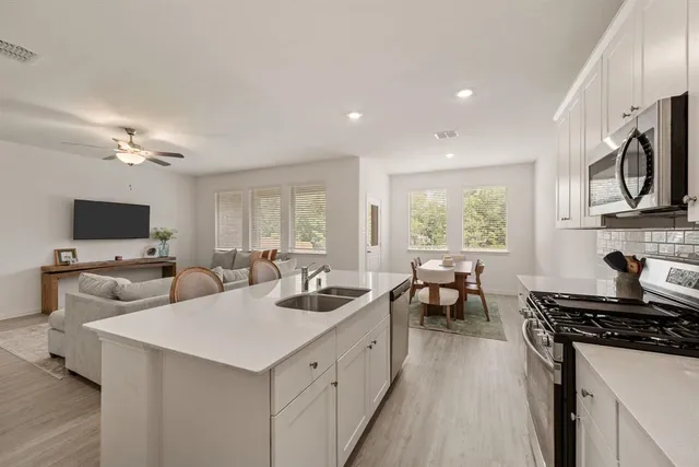 a kitchen with sink refrigerator and stove