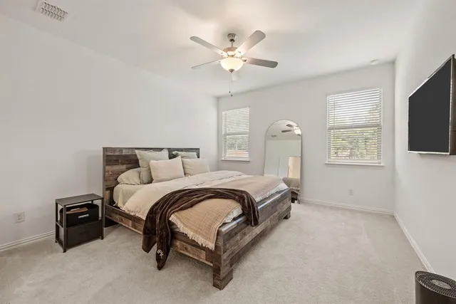 a spacious bedroom with a bed and a flat screen tv