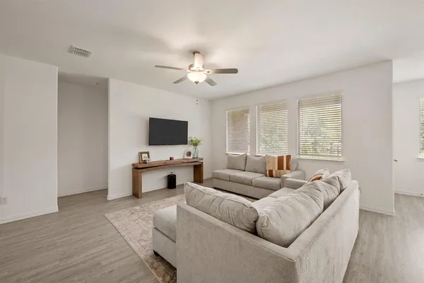 a living room with furniture flat screen tv and a window