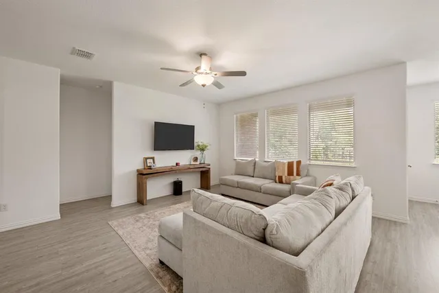 a living room with furniture flat screen tv and a window