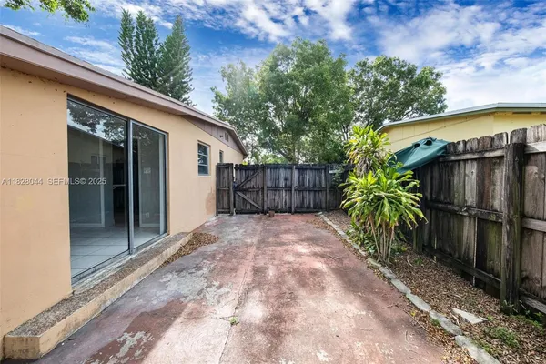 a view of backyard with potted plants and a patio