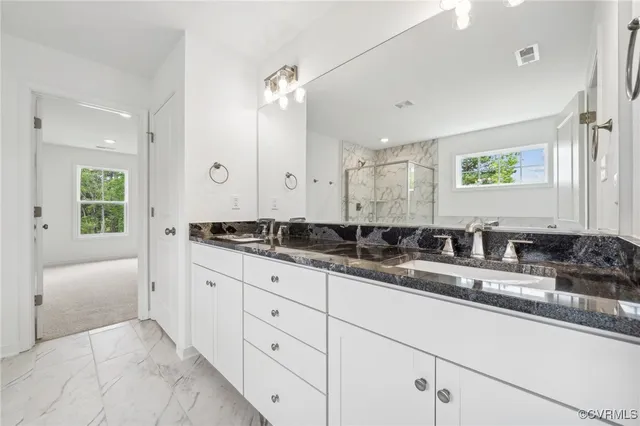 a bathroom with a granite countertop sink mirror and double