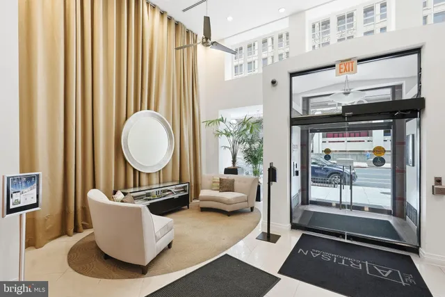 a living room with furniture a window and a potted plant