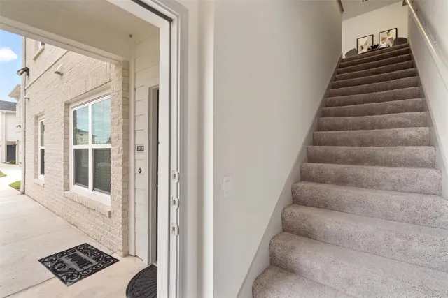 a view of house with a yard and potted plants