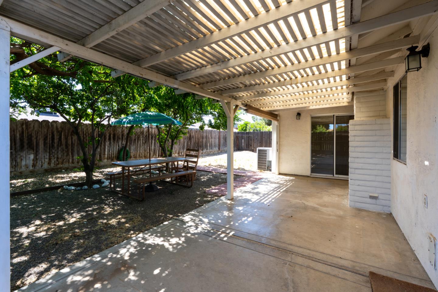 1351 Chukar Street Los Banos, CA 93635 - Photo 28 of 34 a view of a backyard with table and chairs with wooden fence and plants
