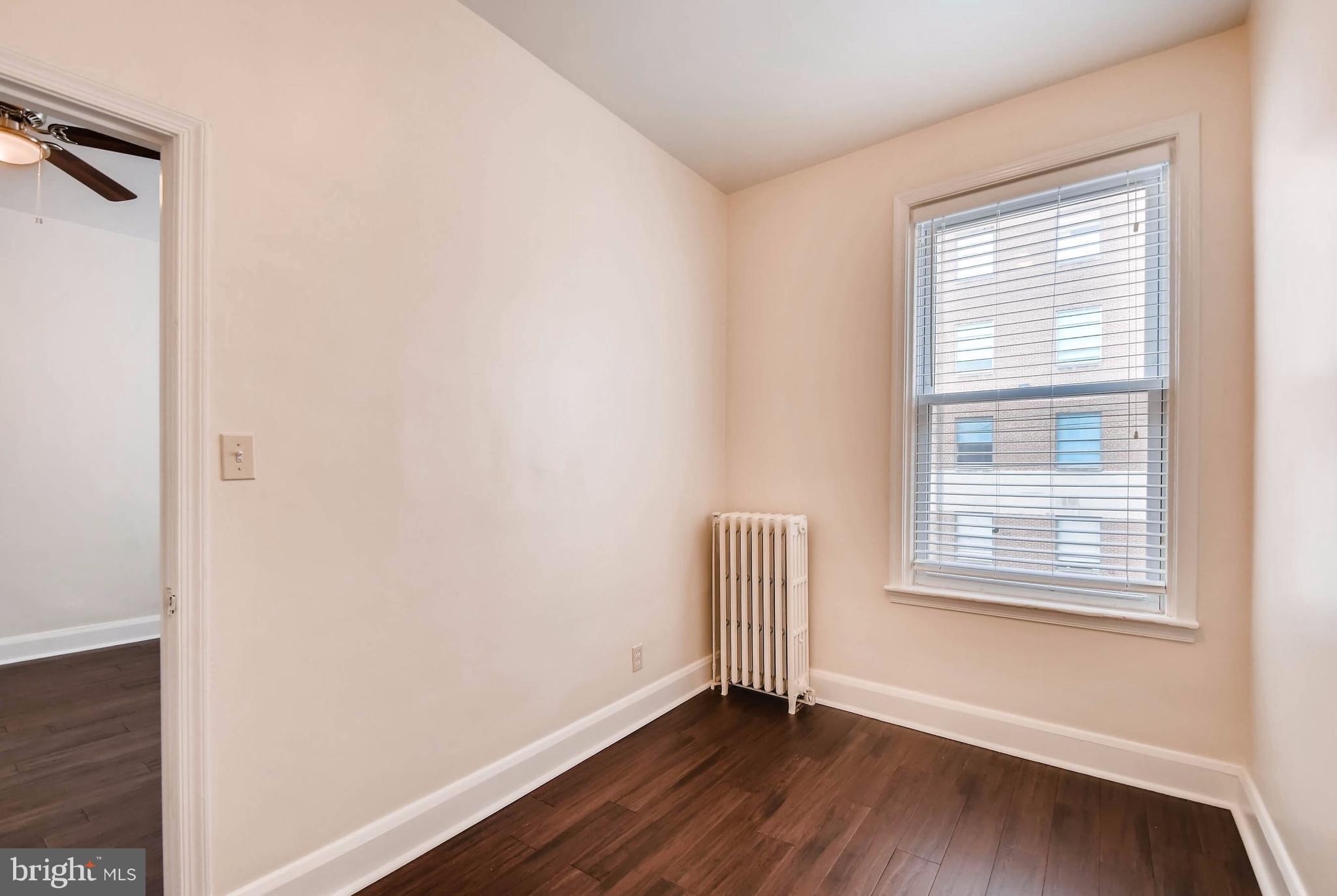843 North Howard Street, Unit 2 Baltimore, MD 21201 - Photo 5 of 16 a view of an empty room with wooden floor and a window