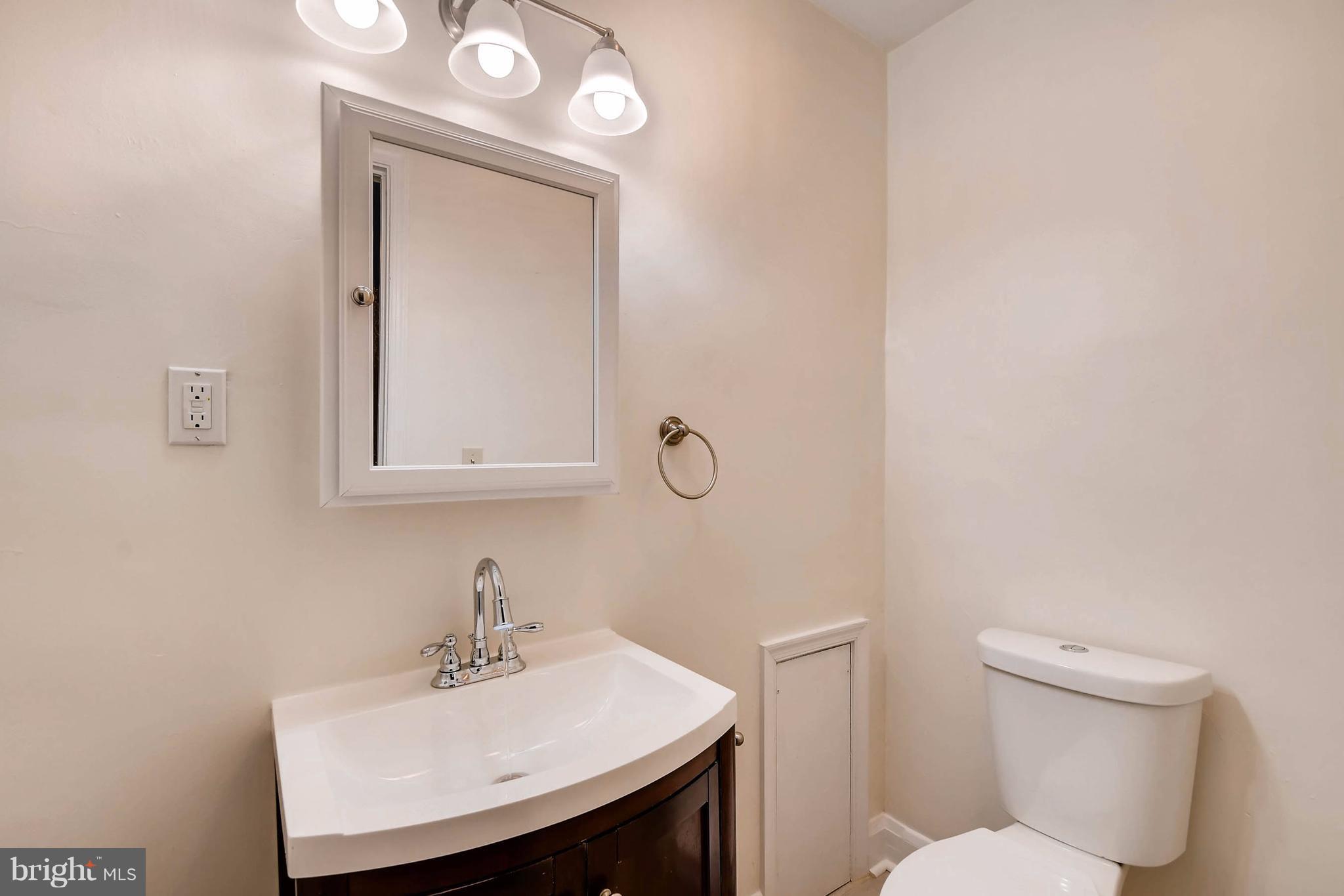 843 North Howard Street, Unit 2 Baltimore, MD 21201 - Photo 6 of 16 a bathroom with a sink a toilet and mirror