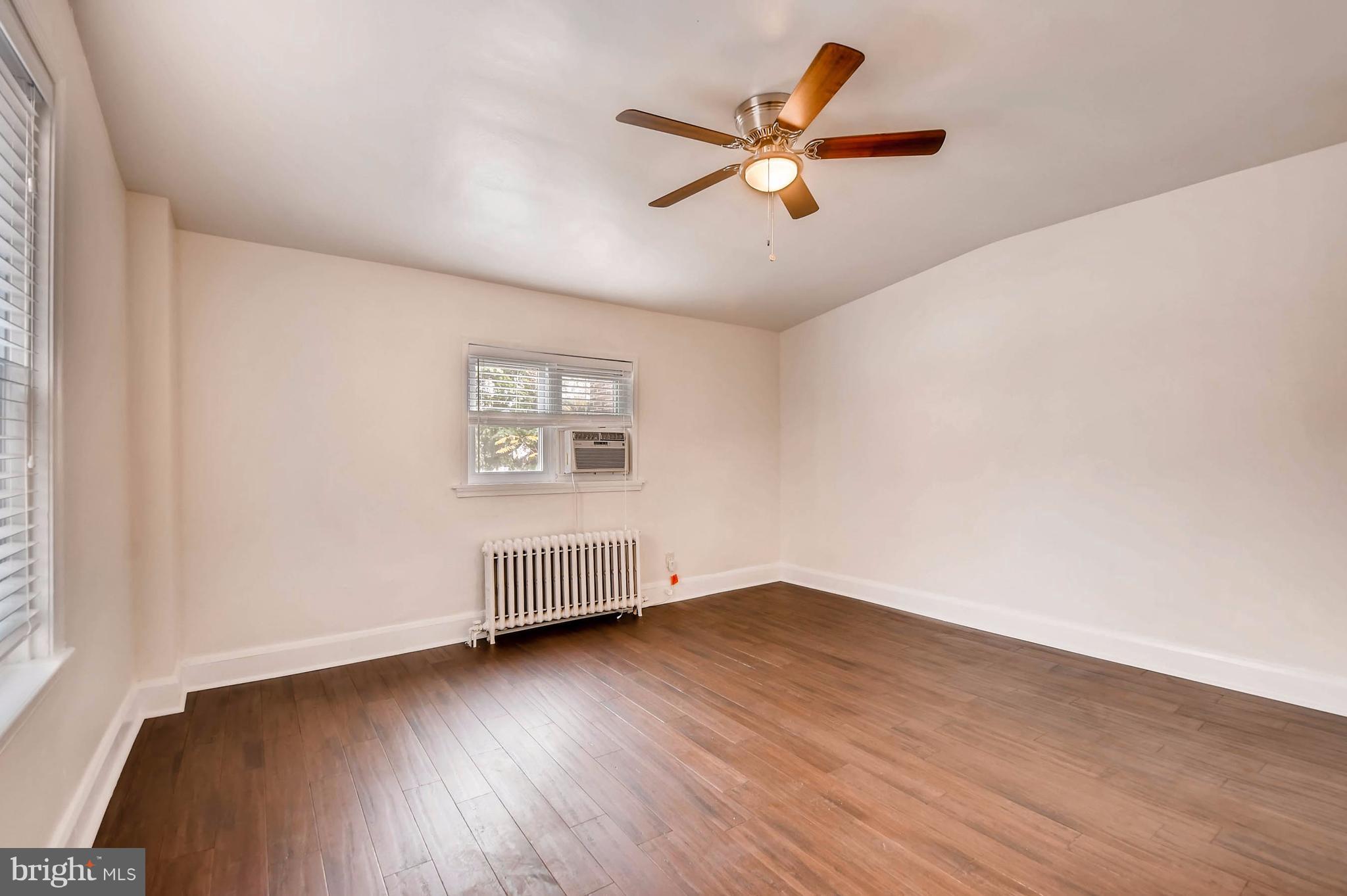 843 North Howard Street, Unit 2 Baltimore, MD 21201 - Photo 7 of 16 an empty room with wooden floor fan and windows