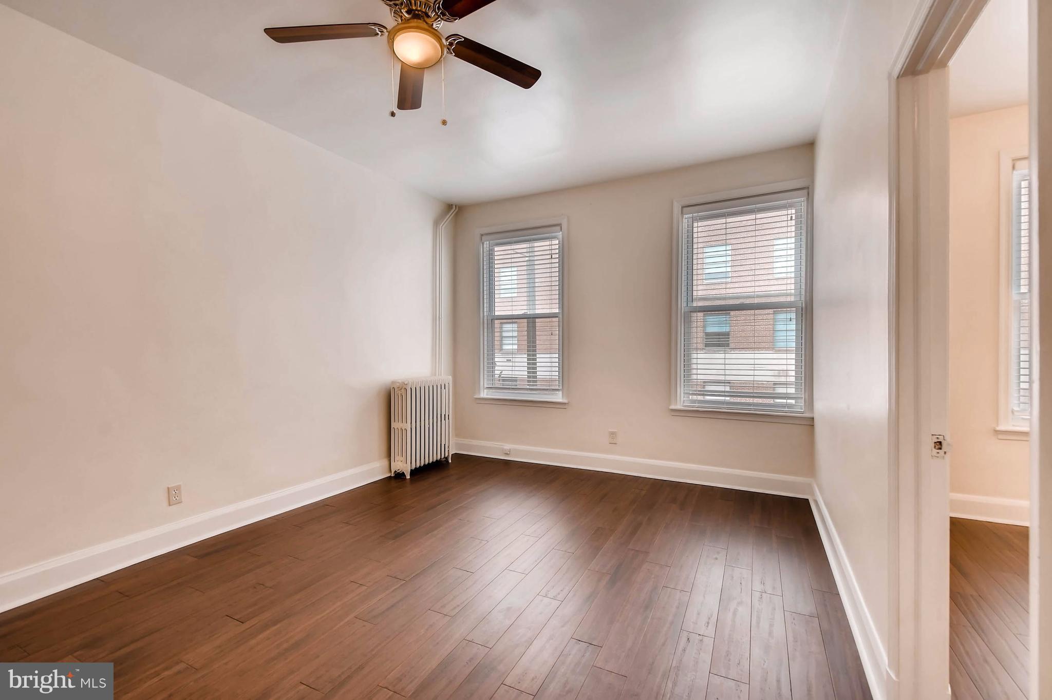 843 North Howard Street, Unit 2 Baltimore, MD 21201 - Photo 10 of 16 an empty room with wooden floor fan and windows