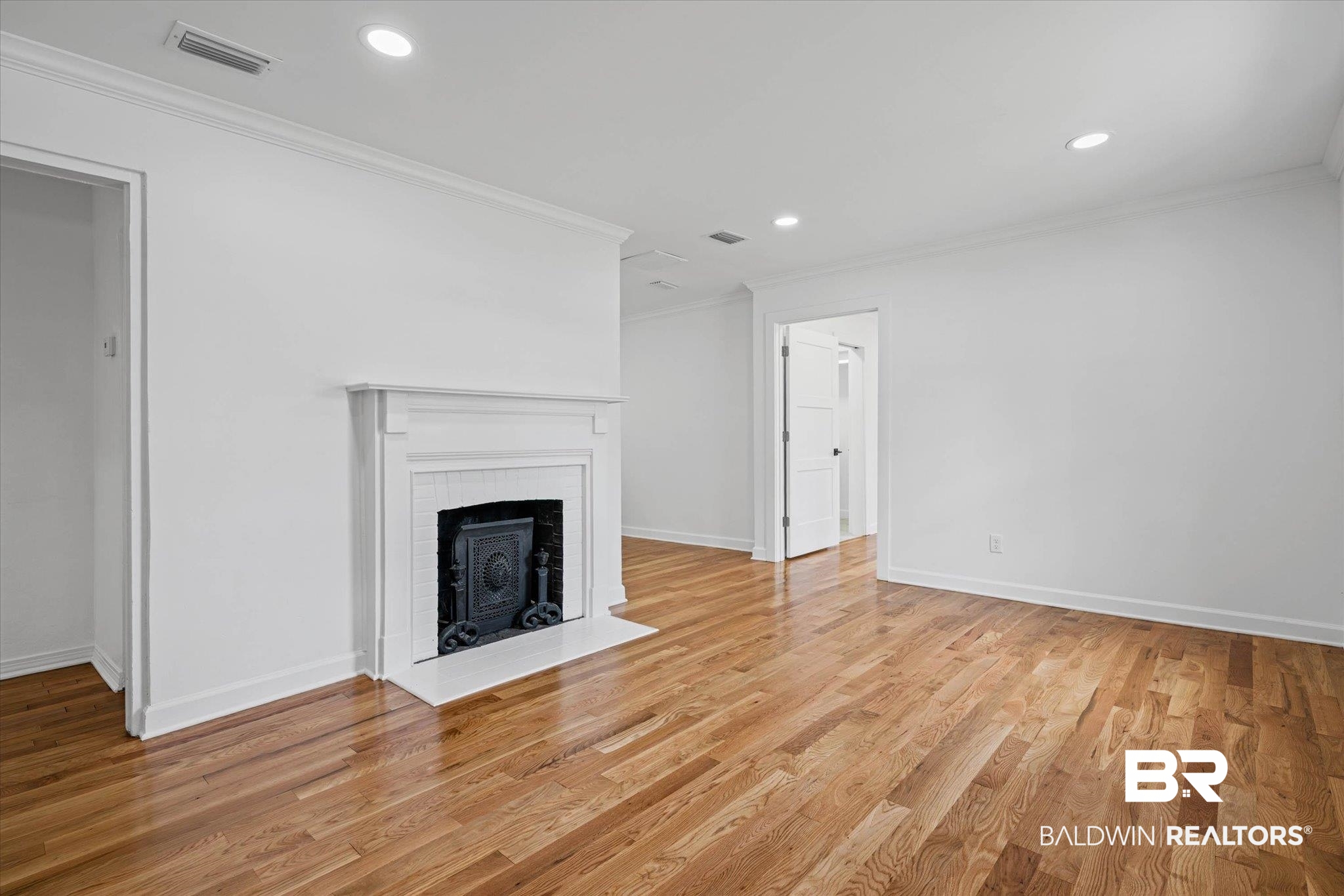 41 Hathaway Road West Mobile, AL 36608 - Photo 2 of 24 Unfurnished living room featuring recessed lighting, ornamental molding, light wood-style flooring, and a fireplace with flush hearth