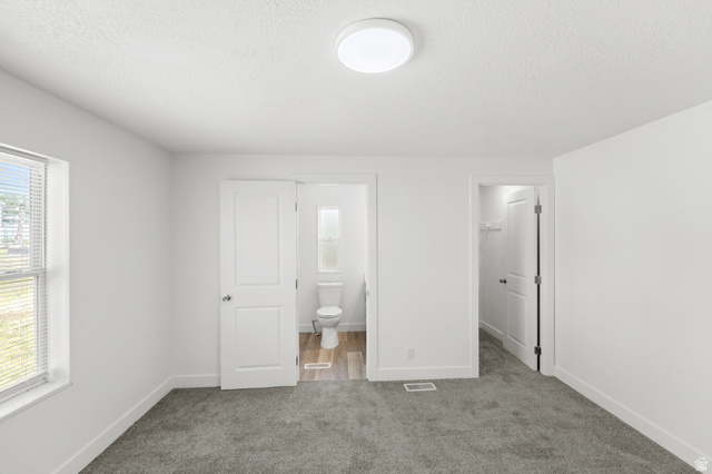 2600 North Hill Field Road, Unit 103A Layton, UT 84041 - Photo 13 of 31 Bedroom featuring neutral grey carpeting, white walls, a flush-mount ceiling light, and a window with horizontal blinds