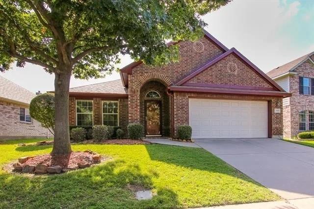 View of front facade with a garage, brick siding, a front lawn, and concrete driveway