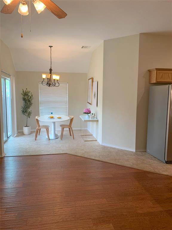 3313 Timber Ridge Trail McKinney, TX 75071 - Photo 6 of 20 Unfurnished dining area featuring baseboards, visible vents, light wood-style floors, lofted ceiling, and ceiling fan with notable chandelier