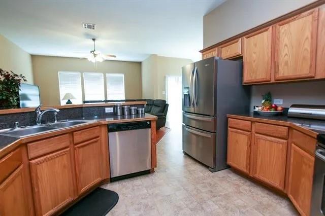 3313 Timber Ridge Trail McKinney, TX 75071 - Photo 8 of 20 Kitchen featuring a sink, dark countertops, visible vents, a ceiling fan, and appliances with stainless steel finishes