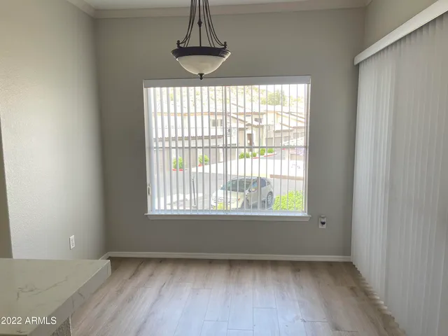 a view of an empty room with chandelier and window
