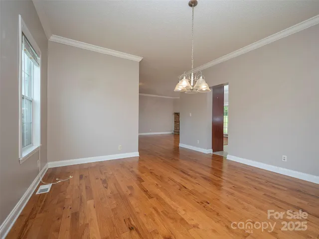 a view of a room with wooden floor and chandelier