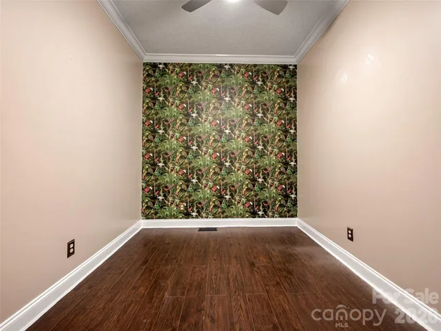 an empty room with wooden floor and natural light