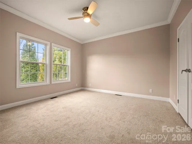 an empty room with windows and fan