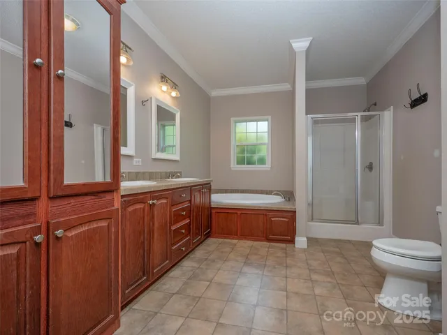 a spacious bathroom with a granite countertop sink toilet mirror and bathtub