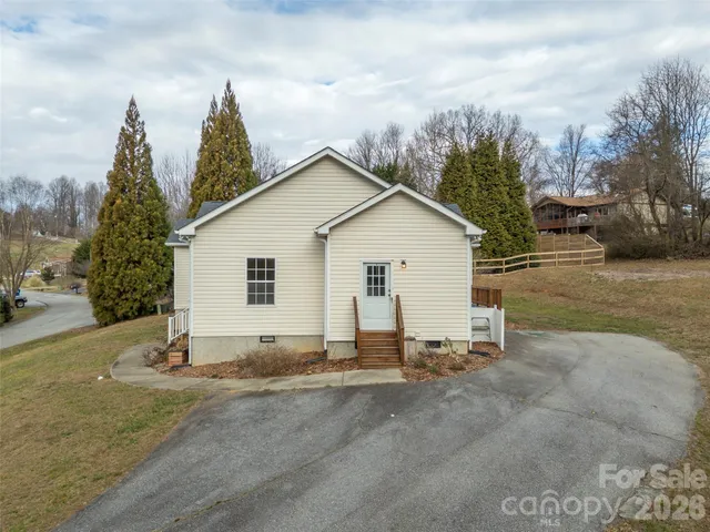 a view of a house with backyard and trees