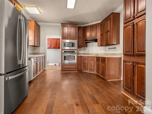 a kitchen with stainless steel appliances a refrigerator and wooden cabinets