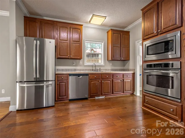 a kitchen with granite countertop stainless steel appliances and wooden cabinets