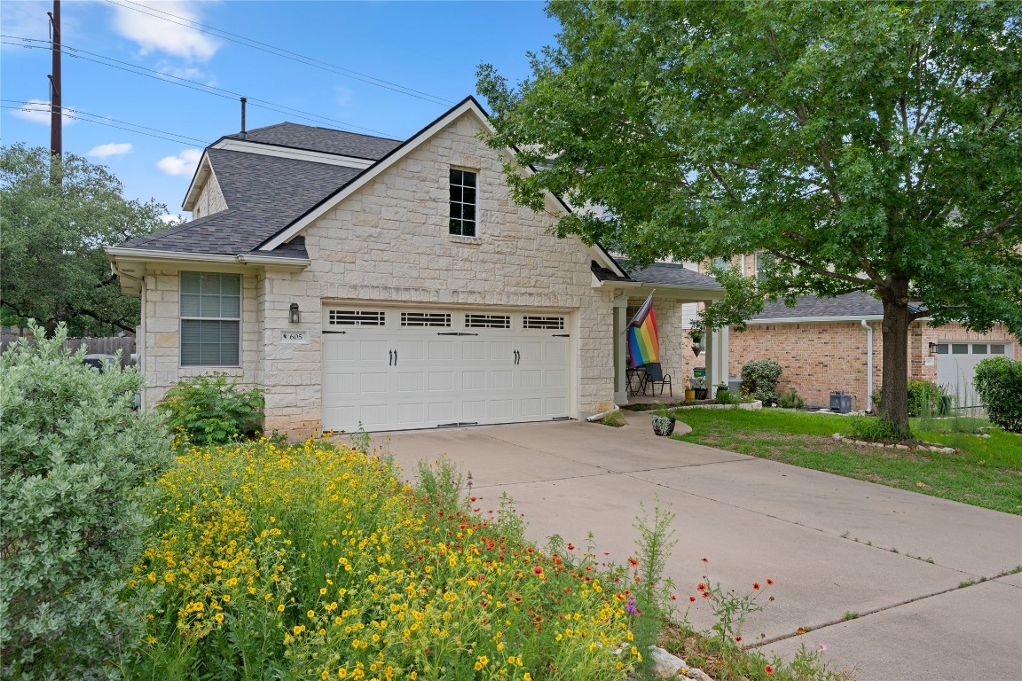 a view of a house with a yard and potted plants