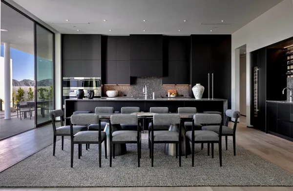 a dining hall with stainless steel appliances granite countertop a dining table and chairs